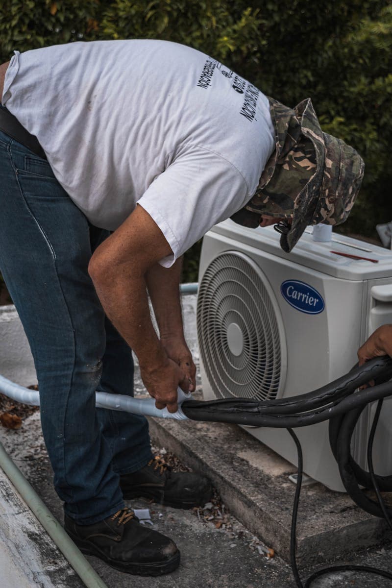 HVAC technician inspecting an outdoor air conditioning unit